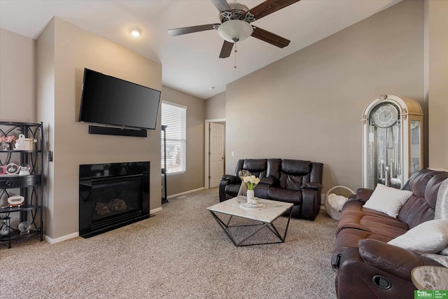 carpeted living room with ceiling fan and high vaulted ceiling