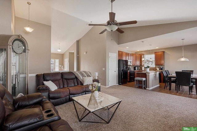 living room featuring ceiling fan, a healthy amount of sunlight, and vaulted ceiling