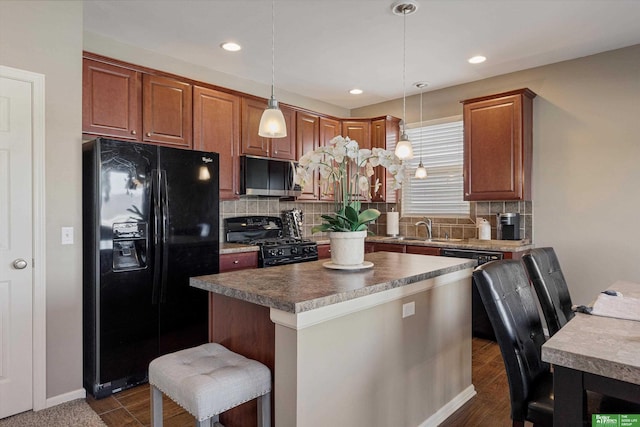 kitchen featuring black appliances, decorative light fixtures, decorative backsplash, and a kitchen island