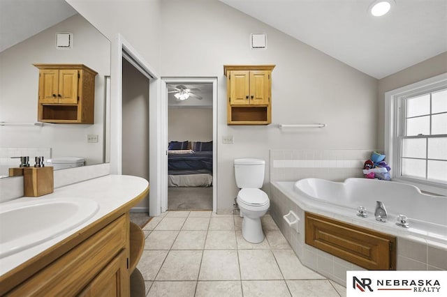 bathroom with lofted ceiling, vanity, tile patterned flooring, toilet, and ceiling fan