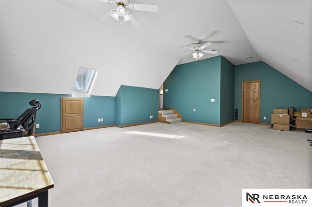 interior space featuring ceiling fan and vaulted ceiling with skylight