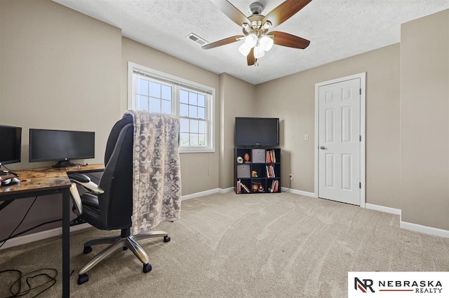 carpeted home office featuring ceiling fan and a textured ceiling