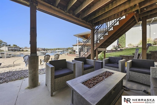 view of patio / terrace featuring a water view and an outdoor living space with a fire pit