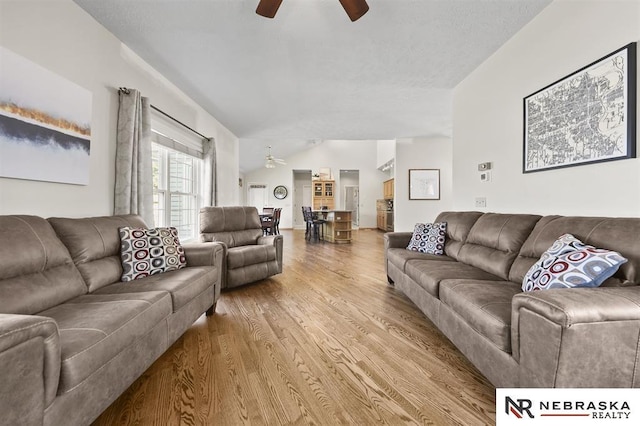 living room with vaulted ceiling, ceiling fan, and hardwood / wood-style floors