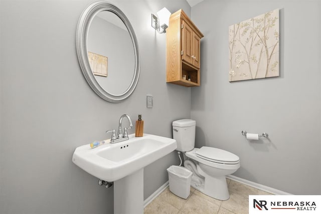 bathroom featuring toilet, tile patterned flooring, and sink