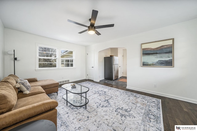 living room with ceiling fan and dark hardwood / wood-style flooring