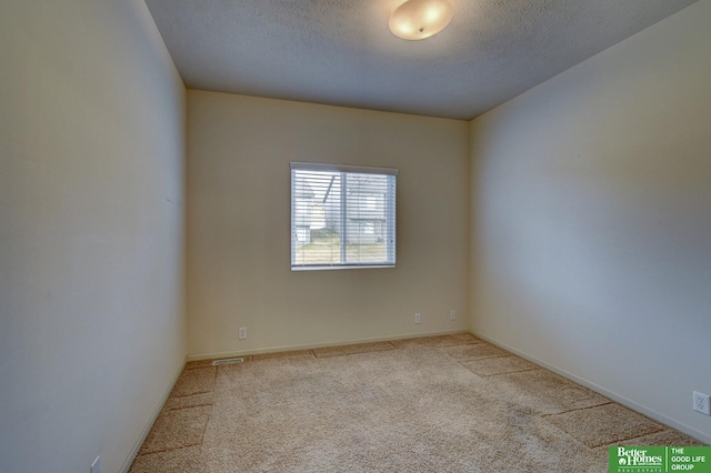 carpeted spare room with a textured ceiling