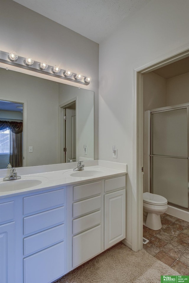 bathroom with walk in shower, vanity, toilet, and a textured ceiling