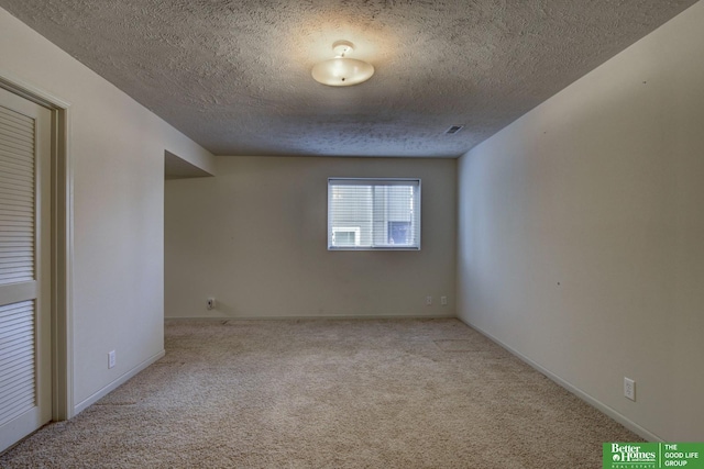 carpeted spare room featuring a textured ceiling