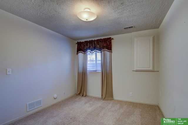 carpeted spare room featuring a textured ceiling