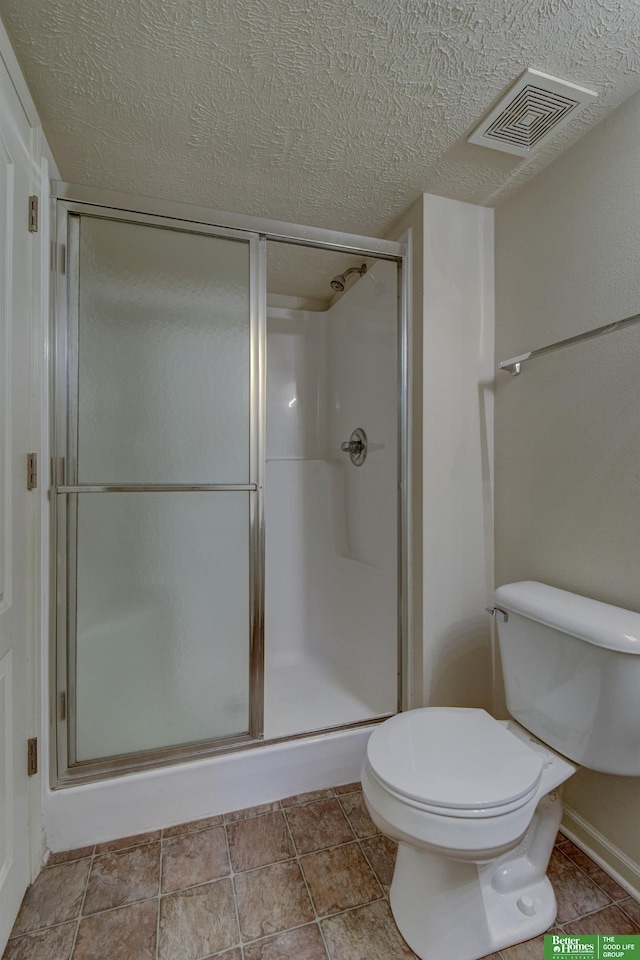 bathroom with toilet, a textured ceiling, and an enclosed shower