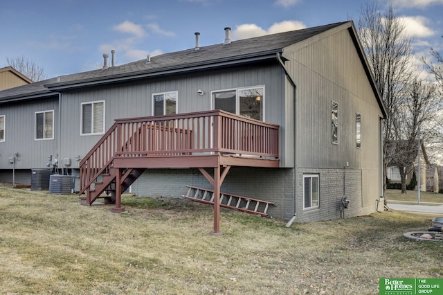 rear view of property with a deck, a yard, and central air condition unit