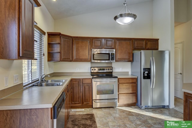 kitchen with hanging light fixtures, appliances with stainless steel finishes, sink, and high vaulted ceiling