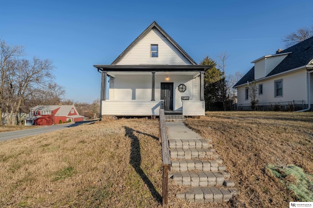 view of front of home featuring covered porch and a front yard