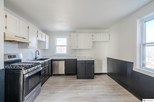 kitchen featuring sink, white cabinets, light hardwood / wood-style flooring, and stainless steel appliances