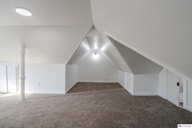 bonus room featuring vaulted ceiling and dark carpet