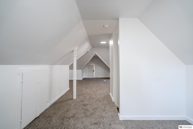 bonus room with lofted ceiling and light colored carpet