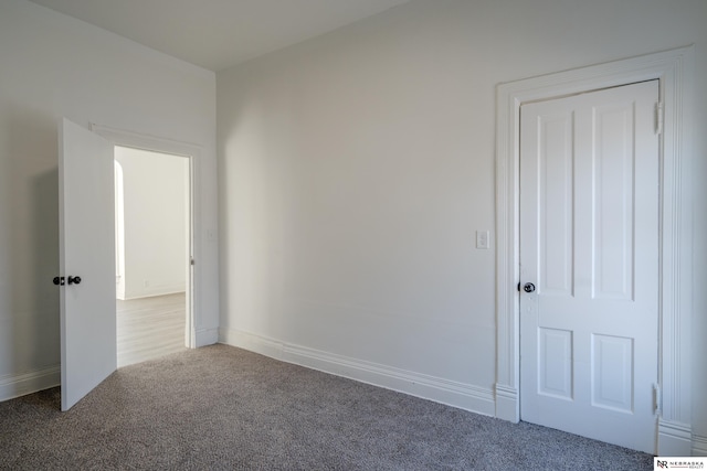 unfurnished room featuring dark colored carpet