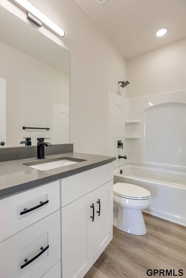 full bathroom featuring hardwood / wood-style floors, toilet, bathtub / shower combination, and vanity