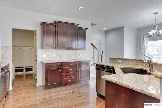 kitchen featuring stainless steel dishwasher, sink, an inviting chandelier, hanging light fixtures, and light stone countertops