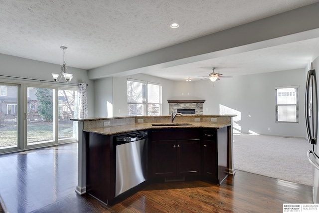 kitchen featuring decorative light fixtures, sink, light stone counters, and dishwasher