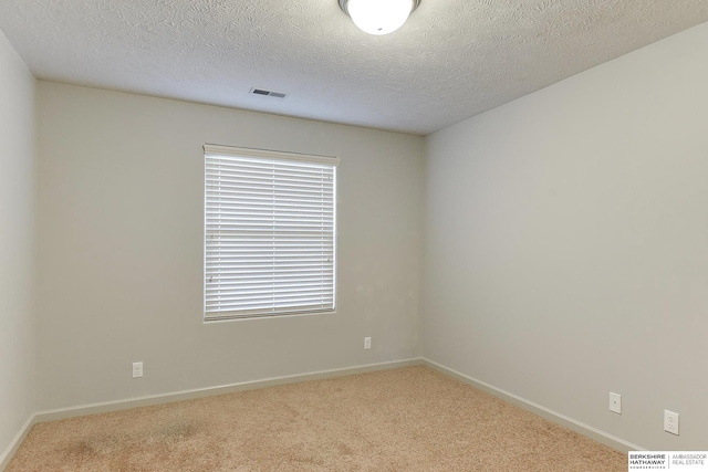 carpeted spare room featuring a textured ceiling