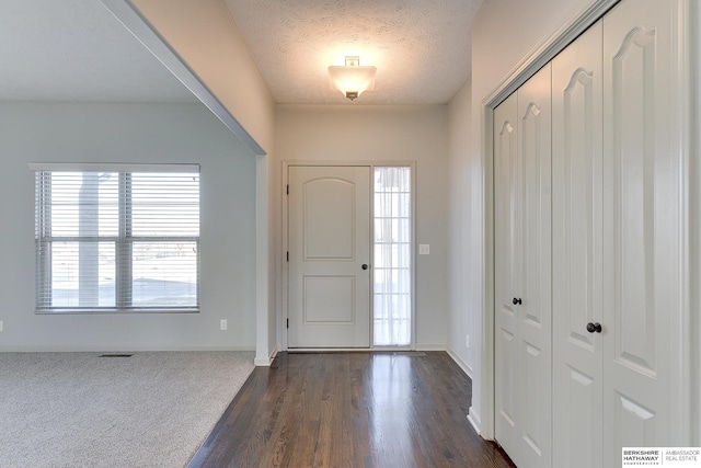 entryway featuring dark wood-type flooring and a textured ceiling