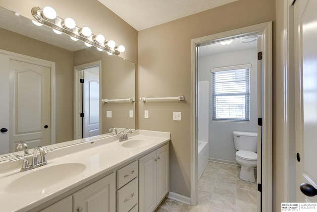 bathroom featuring a textured ceiling, toilet, and vanity