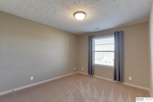 unfurnished room with a textured ceiling and carpet flooring