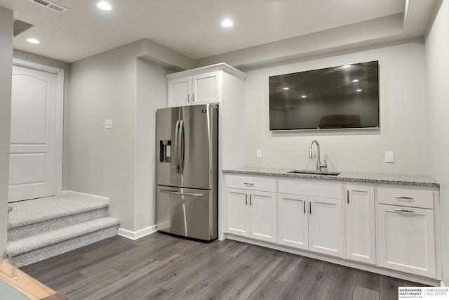 kitchen featuring sink, stainless steel fridge with ice dispenser, white cabinetry, and light hardwood / wood-style flooring