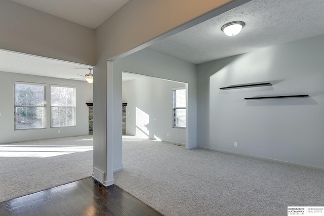 carpeted spare room with ceiling fan and a textured ceiling