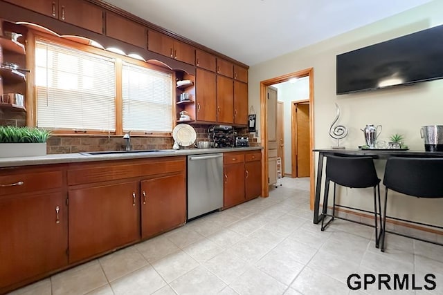 kitchen featuring a kitchen breakfast bar, dishwasher, backsplash, and sink