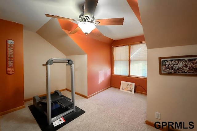 exercise area featuring ceiling fan, light colored carpet, and lofted ceiling