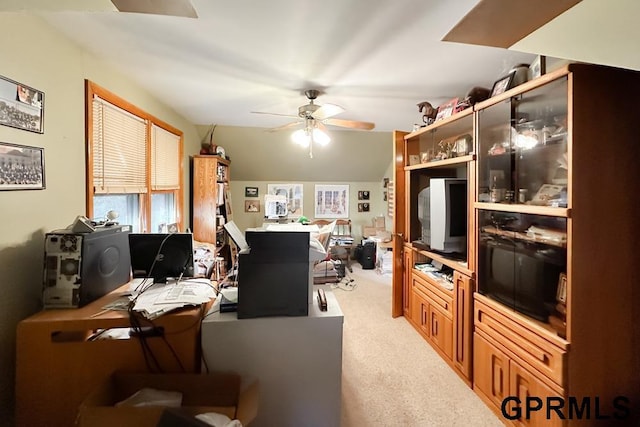 carpeted office featuring vaulted ceiling and ceiling fan