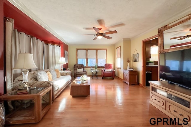 living room with hardwood / wood-style floors, ornamental molding, and a healthy amount of sunlight