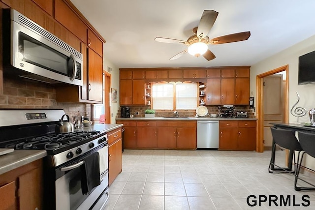 kitchen with ceiling fan, sink, appliances with stainless steel finishes, and tasteful backsplash