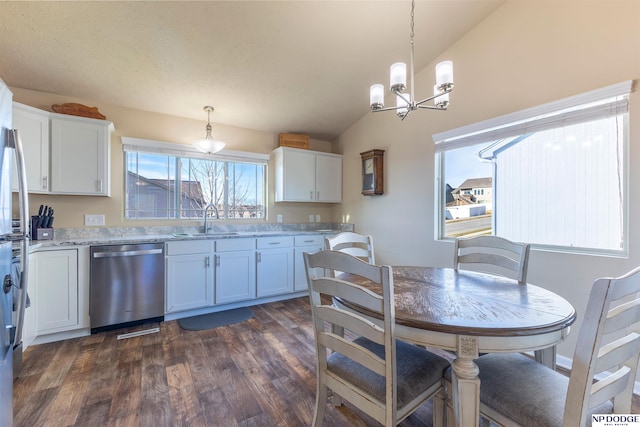 kitchen featuring stainless steel dishwasher, white cabinets, decorative light fixtures, and sink