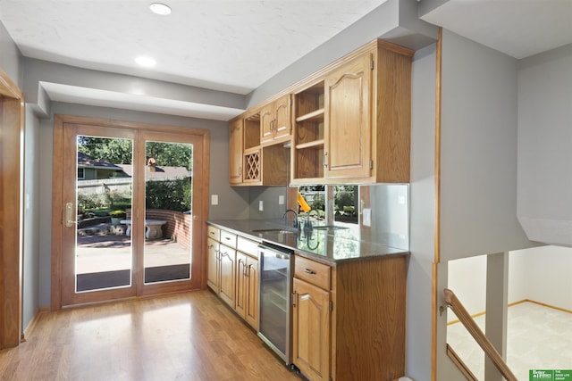 kitchen with sink, light hardwood / wood-style flooring, and wine cooler