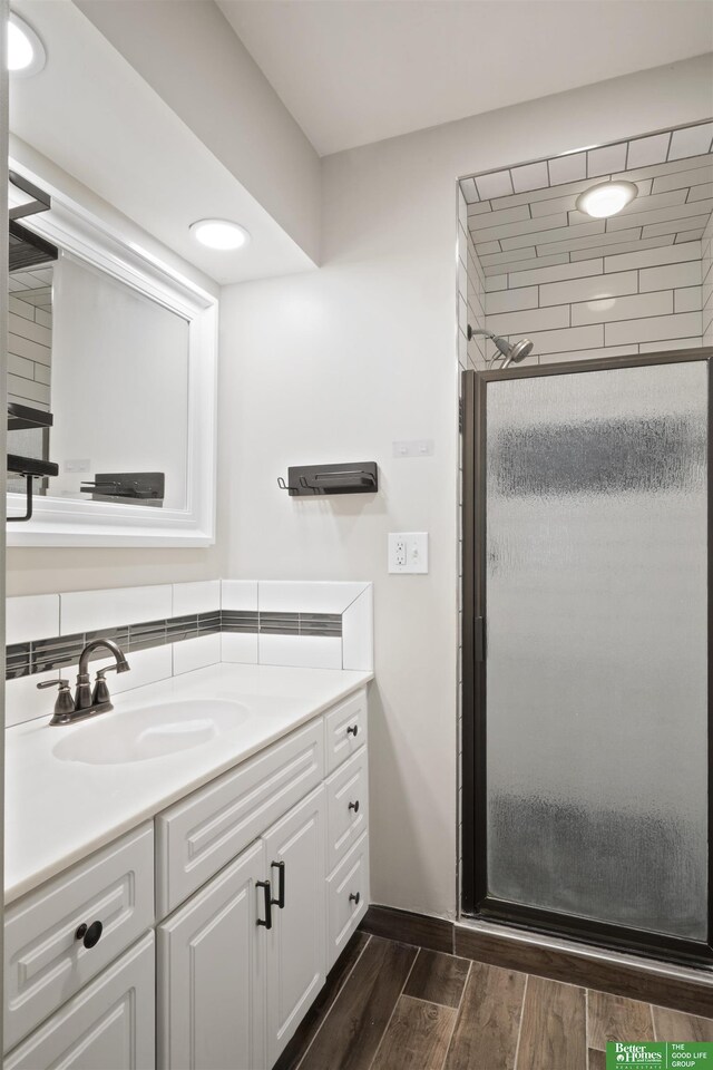 bathroom with vanity and a shower with door