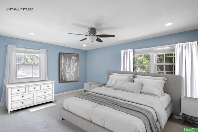 carpeted bedroom with ceiling fan and multiple windows