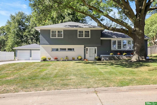 split level home featuring an outbuilding, a front lawn, and a garage