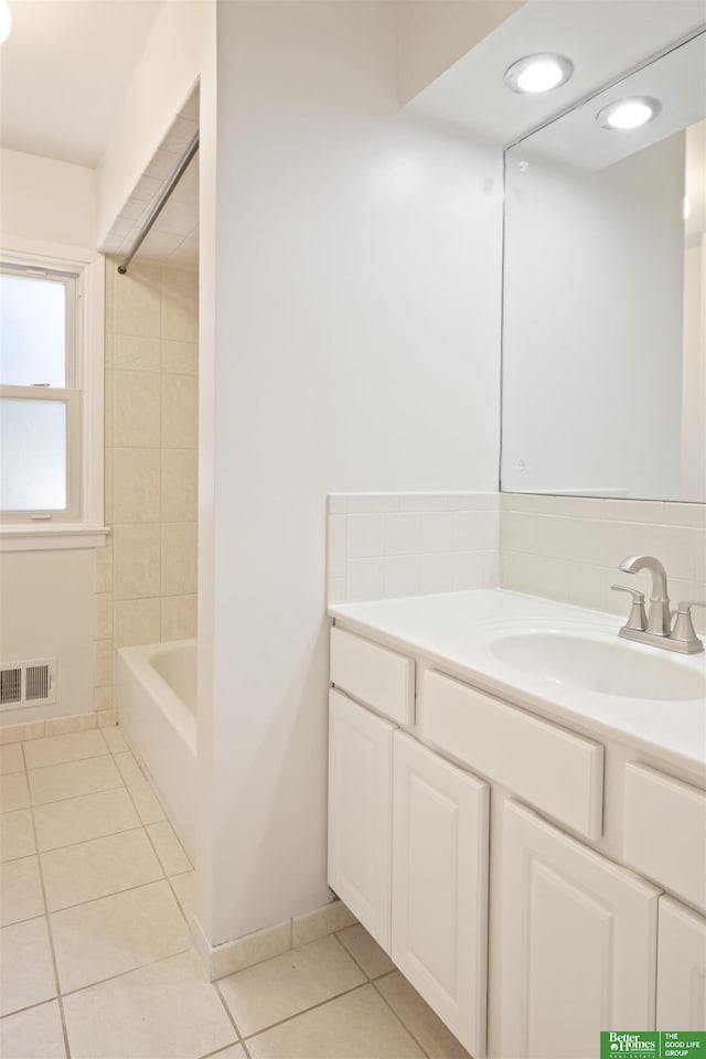 bathroom featuring tile patterned floors, vanity, and tiled shower / bath