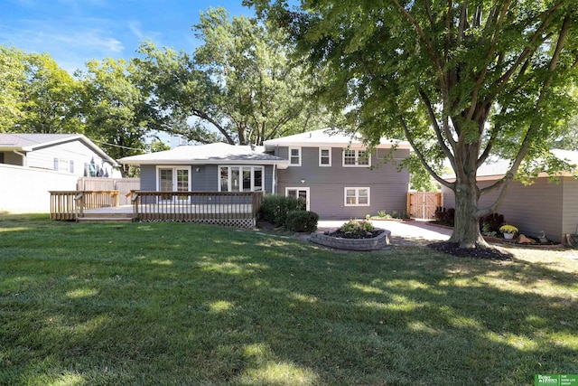 rear view of property with a yard and a wooden deck