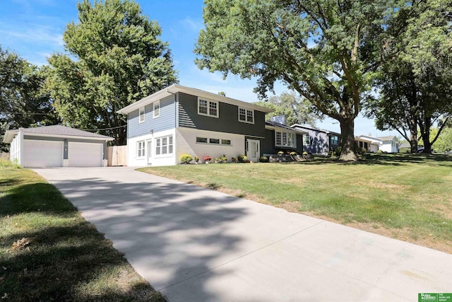 view of front of home featuring a garage, a front yard, and an outbuilding