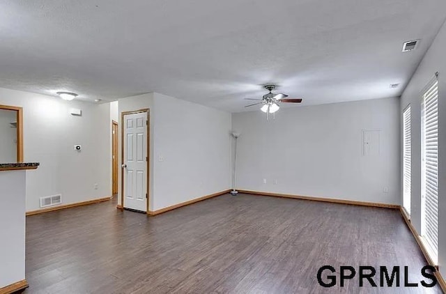 spare room with ceiling fan and dark wood-type flooring