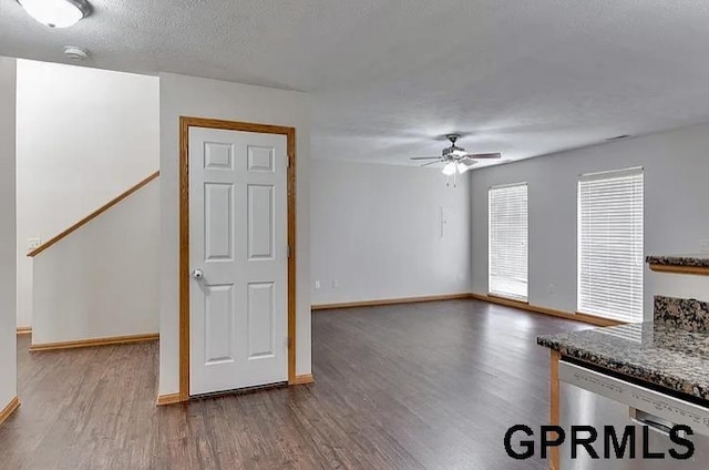 unfurnished living room with a textured ceiling, ceiling fan, and hardwood / wood-style floors