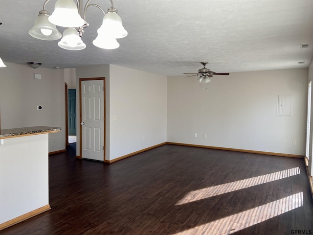 empty room featuring dark hardwood / wood-style floors, ceiling fan with notable chandelier, and a textured ceiling