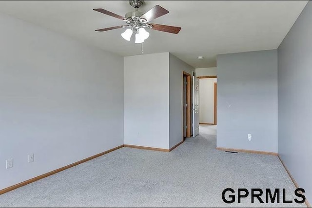 carpeted spare room with ceiling fan