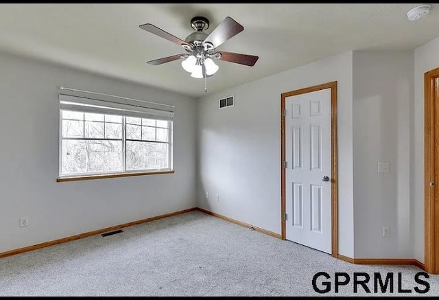 carpeted spare room with ceiling fan