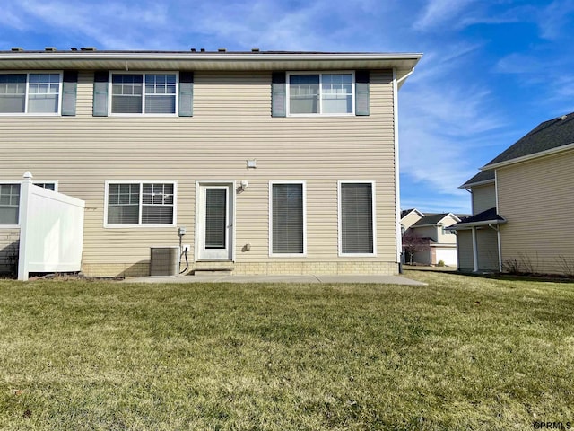 rear view of property with a patio area, central air condition unit, and a yard